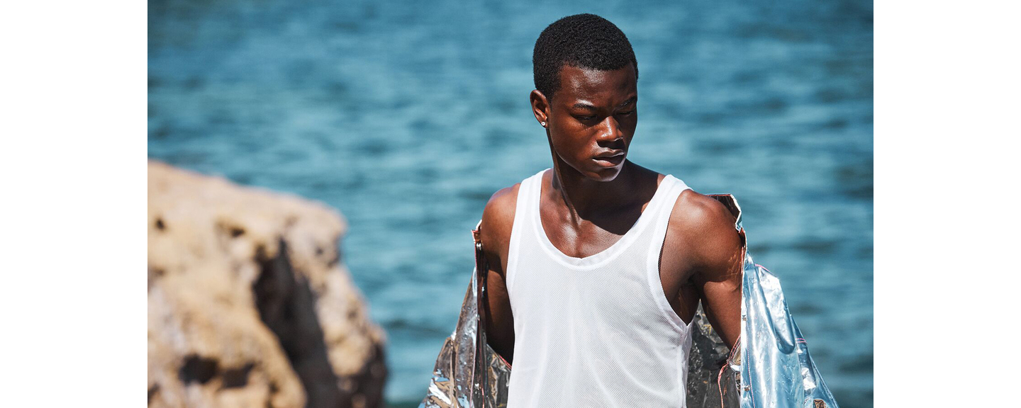 Man with healthy hair contemplating ocean view symbolizing scalp health and wellness
